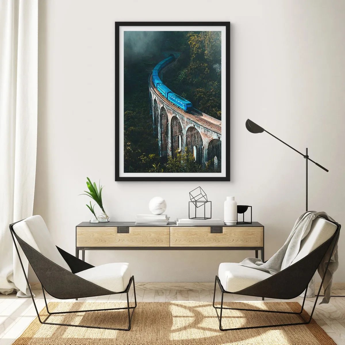 Plakat i sort ramme - Et blåt tog kører over en malerisk viadukt - 50x70cm - Tog til naturen - Moderne vægdekoration til stue og soveværelse ARTTOR